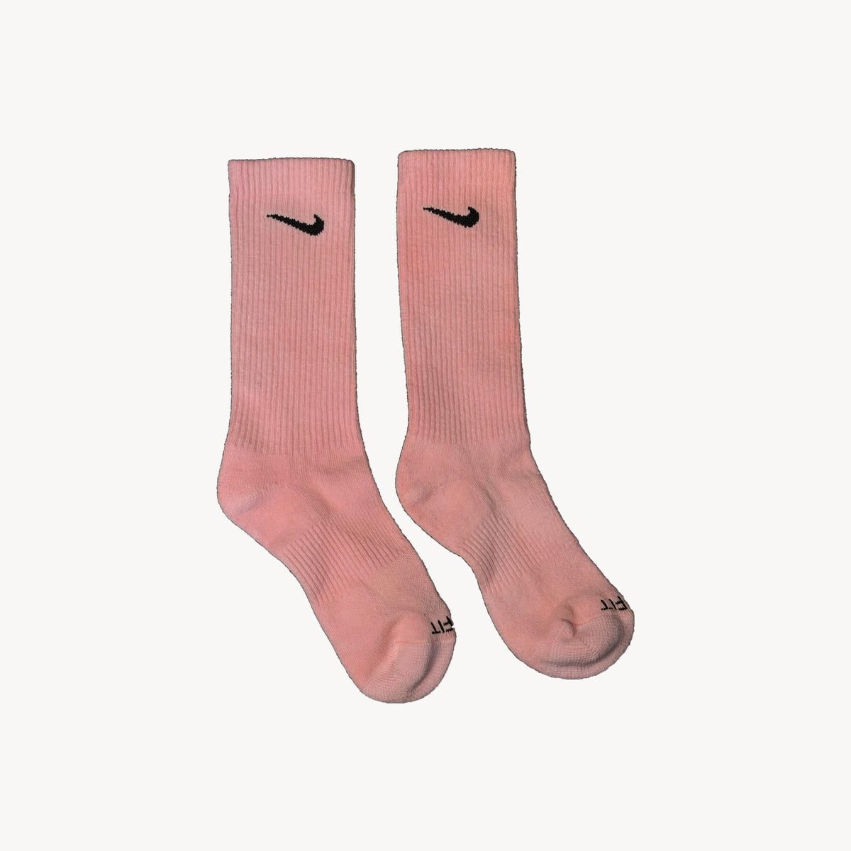 Pair of hand-dyed pink crew socks with black swooshes
